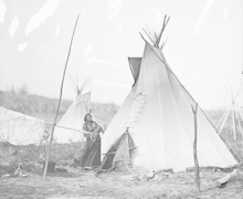 1868 Omaha woman holding infant wutside Chief Gi-He-Gas's tipi